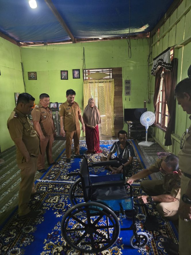 
 Bupati dan Sekda Koltim  menyerahkan bantuan kursi roda kepada salah seorang warga. 